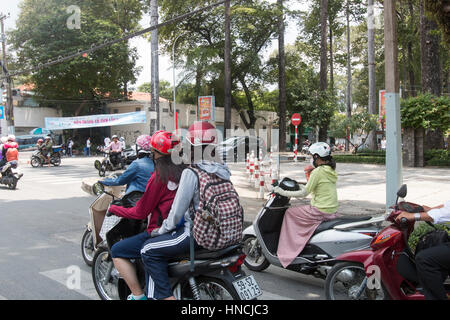 Scooter motorbike riders travelling through Ho Chi Minh city in Vietnam,Asia Stock Photo