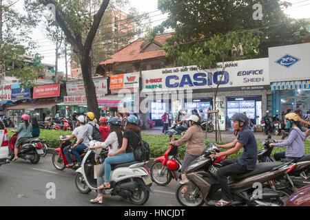 Scooter motorbike riders travelling through Ho Chi Minh city in Vietnam,Asia Stock Photo