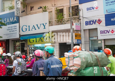 Scooter motorbike riders travelling through Ho Chi Minh city in Vietnam,Asia Stock Photo