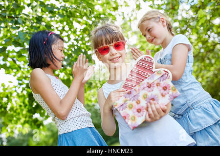 Girls clap their hands for birthday girl at party in summer Stock Photo