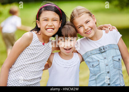 Three laughing girls as friends in intercultural happy team portrait Stock Photo