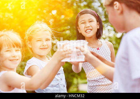 Group of girls drinking water in summer as friends at childrens birthday party Stock Photo