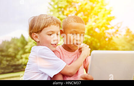 Boys with laptop learning about technology in the park in summer Stock Photo