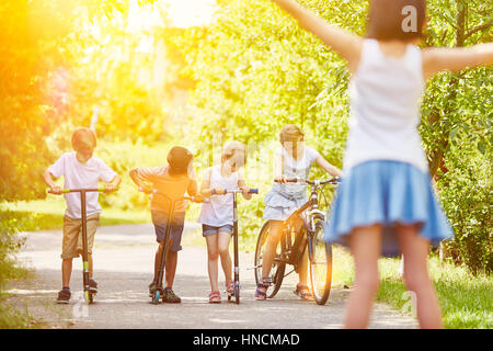 Children at race in the park with bicycle and scooters Stock Photo