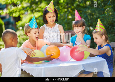 Children having fun at interracial childrens party in summer in garden Stock Photo