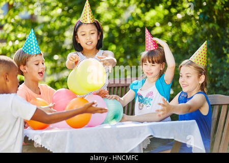Children celebrate birthday of friend and have fun in summer Stock Photo