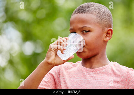 African kid drkining water from plastic cup Stock Photo