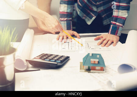 architects team working with new house project blueprints in office Stock Photo
