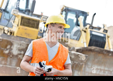 Happy supervisor looking away at construction site Stock Photo