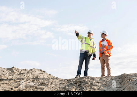 Low angle view of supervisor showing something to colleague at construction site Stock Photo