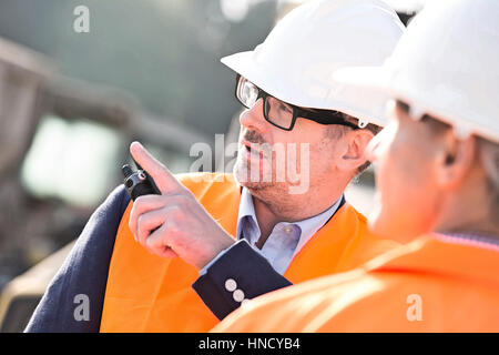 Supervisor showing something to colleague at construction site Stock Photo