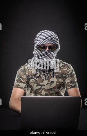 Terrorist working on his computer. Concept about international crisis, war and terrorism Stock Photo