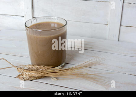 Traditional Drink from Balkan Peninsula Boza (fermented cereal beverage) and wheat over white wooden background Stock Photo