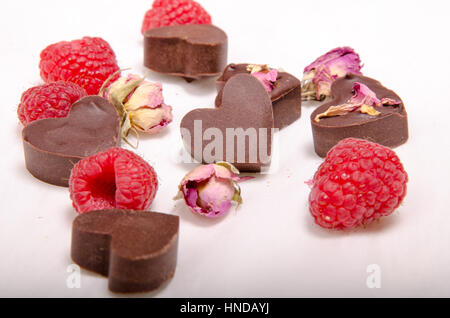 Raw chocolate hearts, roses and raspberries Stock Photo