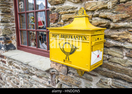 Marksburg, Germany - May 23, 2016: Retro yellow public post mailbox on a wall in Marksburg, Braubach, Germany. Stock Photo