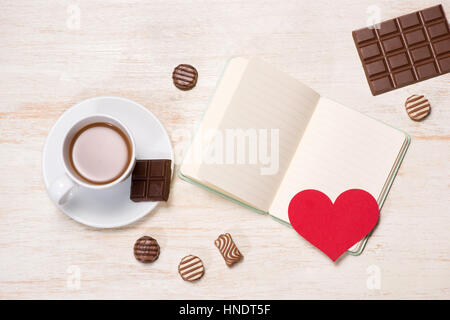 Valentines Day background with chocolate balls, coffee cup, red hearts and notebook Stock Photo