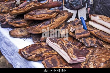 Domestic smoked bacon and other traditional smoked products exposed to sale. Stock Photo