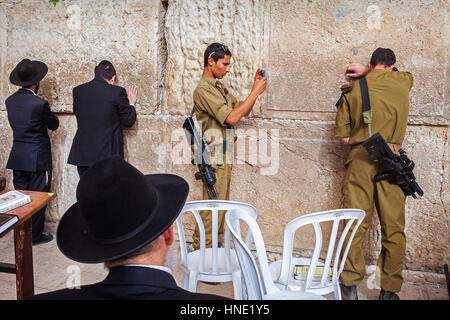 Soldiers, Wailing Wall, men's prayer area, men praying at the Western Walll, Jewish Quarter, Old City, Jerusalem, Israel. Stock Photo