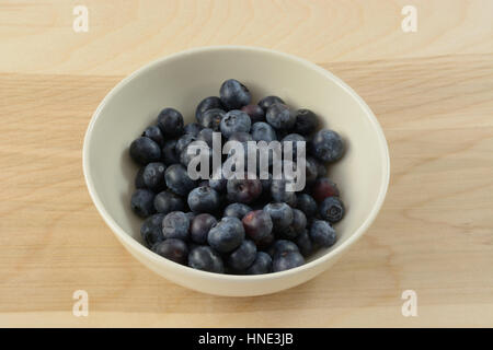 Fresh blueberries in white bowl on wooden table Stock Photo