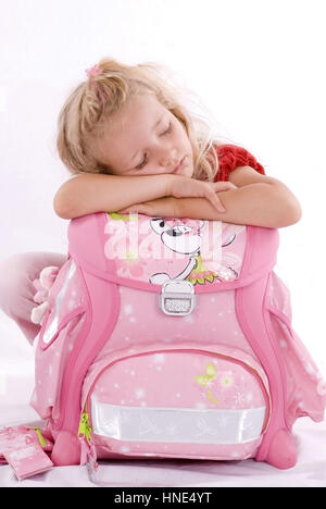 Model release, Schulmaedchen schlaeft auf Schulranzen - school girl sleeping on school bag Stock Photo