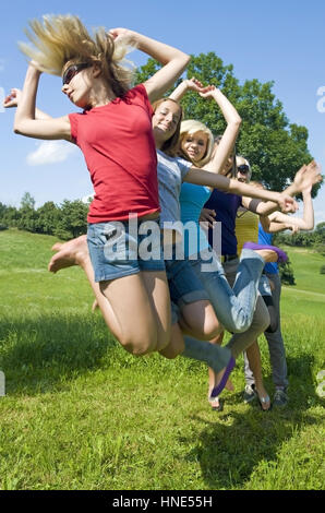 Model release, Jugendliche Maedchen springen in der Wiese - teenage girls jumping in meadow Stock Photo