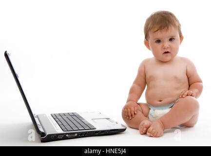 Model release, Kleinkind, 8 Monate, sitzt neben Laptop - little child with laptop Stock Photo