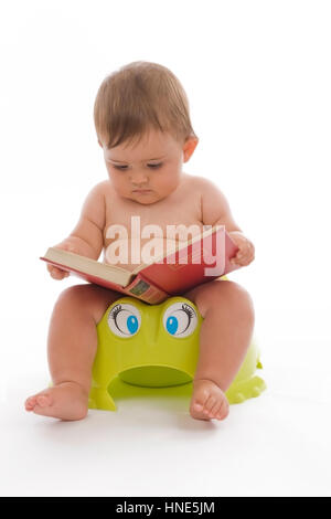 Model release, Kleinkind, 8 Monate, sitzt am Topf und liest ein Buch - little child sitting on potty Stock Photo