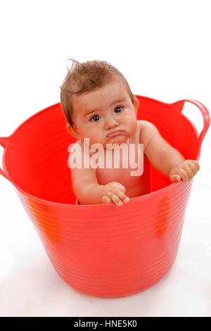 Model release, Kleinkind, 8 Monate, sitzt in roter Wanne - little child in red tub Stock Photo