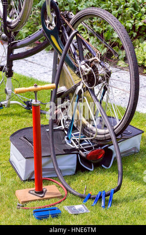 Bicycle upside down on grass outside for flat tire reparation Stock Photo