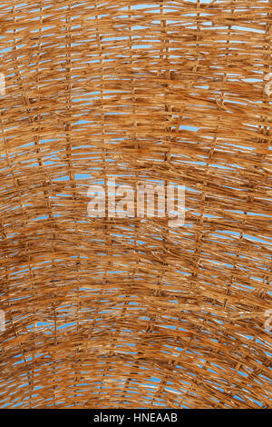 through a straw umbrella from the sun can be seen close up the sky. Stock Photo