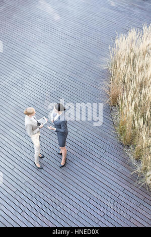 High angle view of businesswomen discussing on floorboard Stock Photo