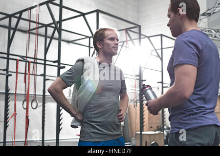Male friends talking in crossfit gym Stock Photo