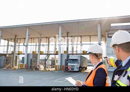 Supervisors looking at truck entering in shipping yard Stock Photo