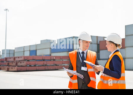 Workers discussing in shipping yard Stock Photo