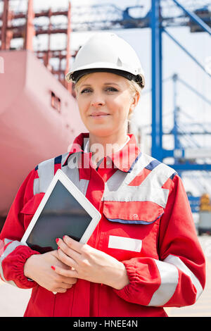 Portrait of confident female engineer holding tablet computer in shipping yard Stock Photo