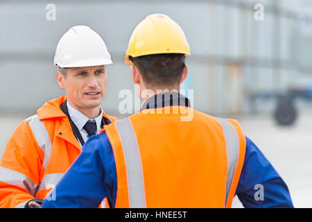 Workers conversing in shipping yard