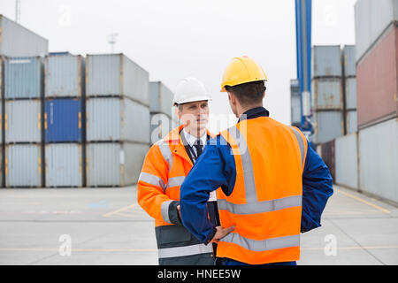 Workers conversing in shipping yard