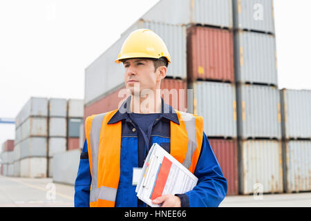 Mid adult man with clipboard in shipping yard Stock Photo