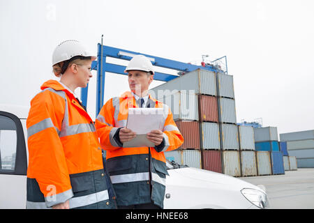 Workers conversing in shipping yard