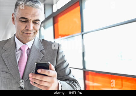 Middle aged businessman using cell phone at railroad station Stock Photo