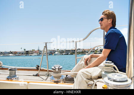 Full-length side view of man sitting on yacht Stock Photo