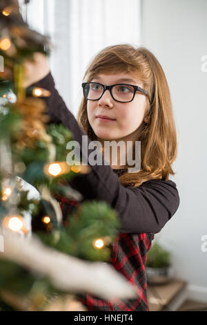 Girl decorating Christmas tree Stock Photo - Alamy