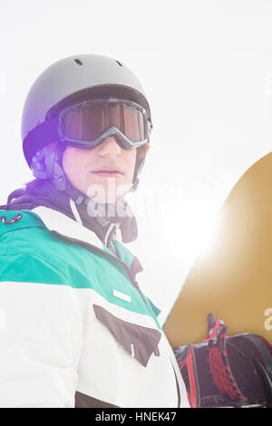Handsome young man holding snowboard outdoors Stock Photo - Alamy