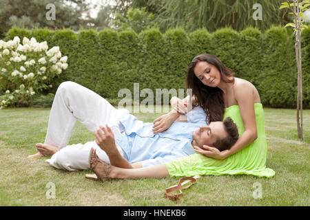 Full length of young man lying on woman's lap in park Stock Photo