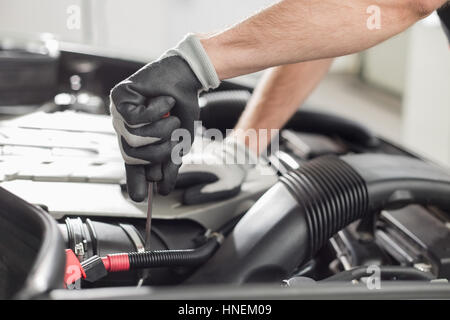 Cropped image of automobile mechanic repairing car in automobile store Stock Photo