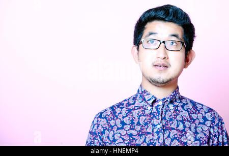 Young Geeky Asian Man in colorful shirt wearing glasses Stock Photo