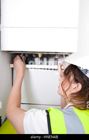 Female plumber servicing central heating boiler Stock Photo