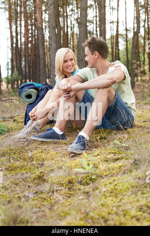 Full length of happy young hiking relaxing in forest Stock Photo