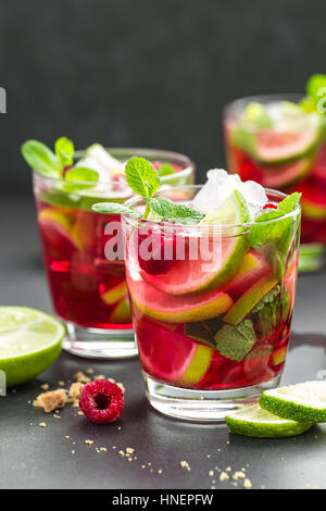 Raspberry mojito cocktail with lime, mint and ice, cold refreshing drink Stock Photo