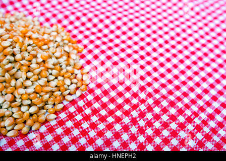 Corn kernels close up on a red and white tablecloth Stock Photo